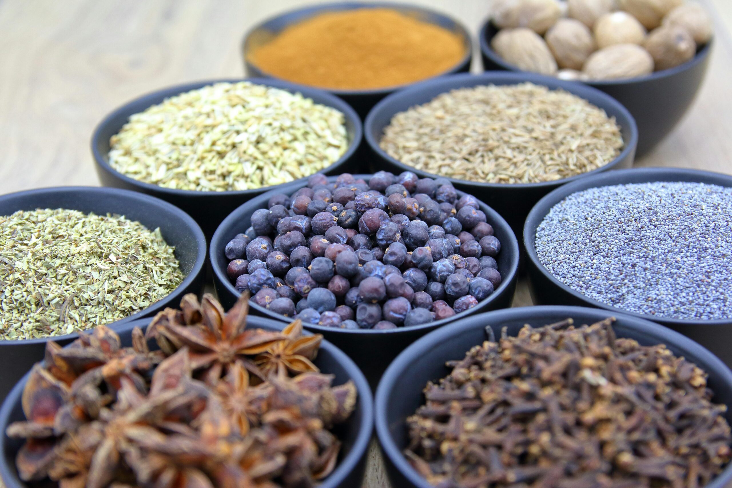 Home Top view of assorted spices in black bowls showcasing different colors and textures.